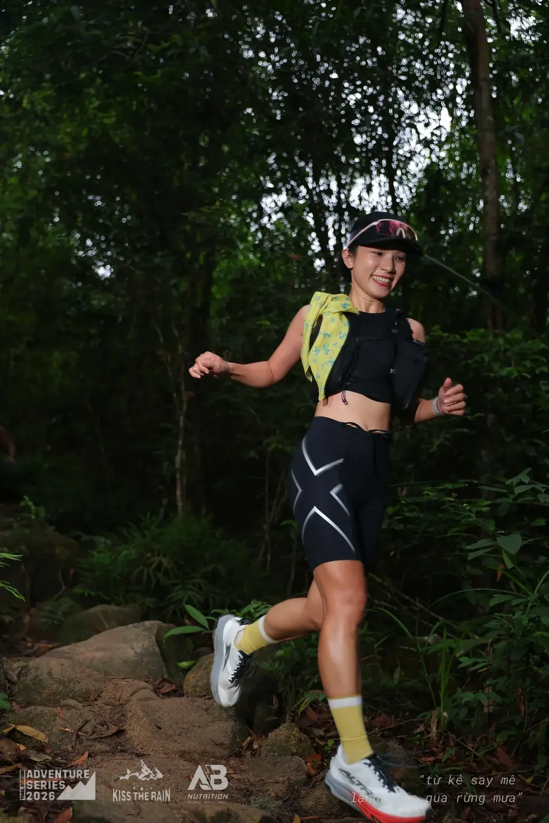 Runner nữ đang chạy qua địa hình đá dưới tán cây