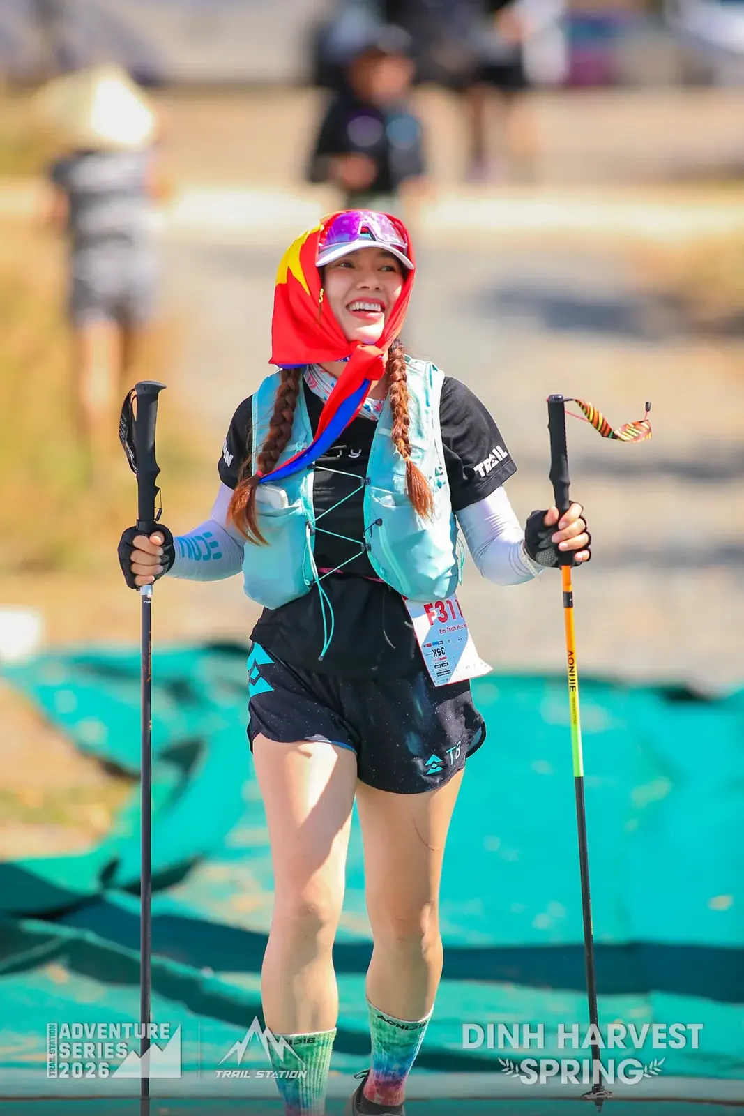 Nữ runner tươi cười cầm gậy chạy bộ tại Dinh Harvest Spring